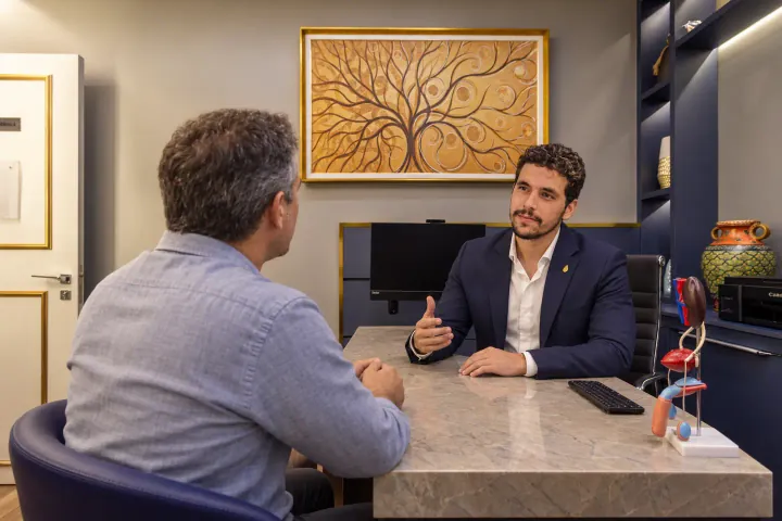 Conversa reservada sobre saúde sexual masculina em consultório da Prime Medical Center.