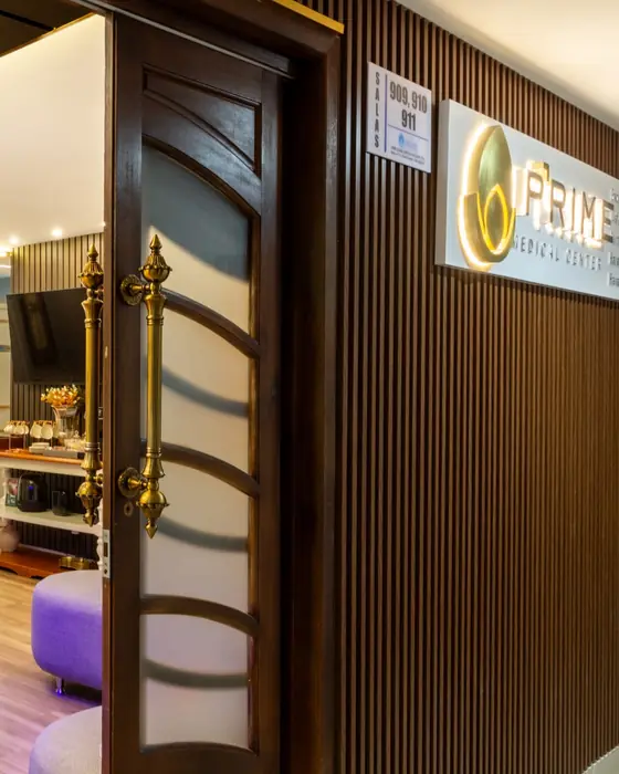 Entrada da Prime Medical Center, com portas de madeira abertas para a recepção.