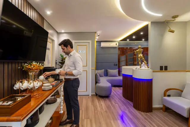 Paciente se servindo de café no espaço de conveniência da clínica.